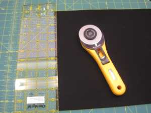 Next I use the straight edge of the ruler to finish the edge of my fabric off. Essentially I am cutting away in rough edges. My favorite Ruler is a  Olfa $' x 16" and my favorite cutter is a Olfa 45mm with an old school handle.